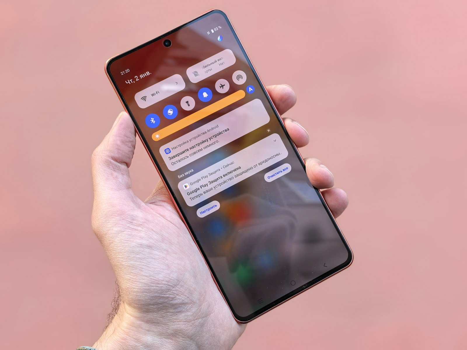 A hand holding a smartphone showing notifications, representing the Gmail inbox and Promotions tab