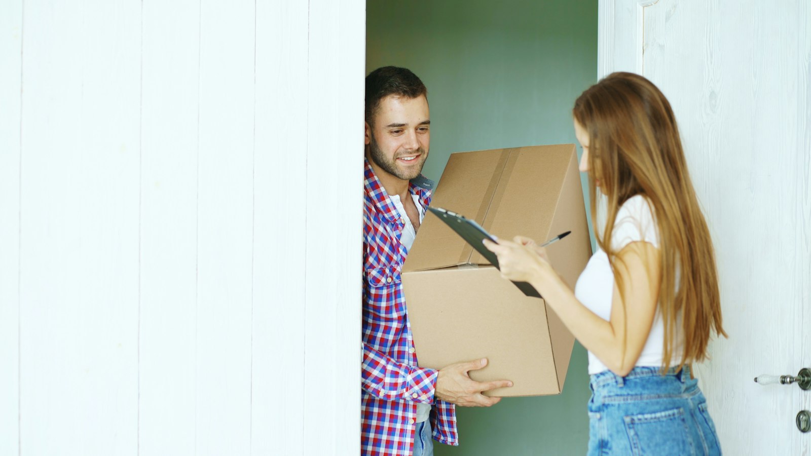 A customer signing for a package delivery at a front door, representing an order confirmation email